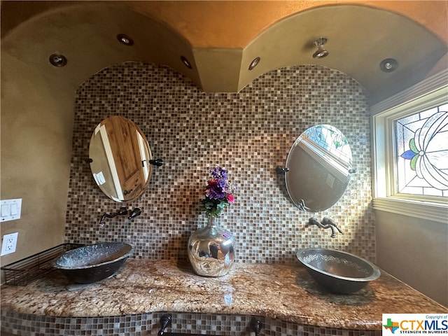 bathroom with sink and tasteful backsplash