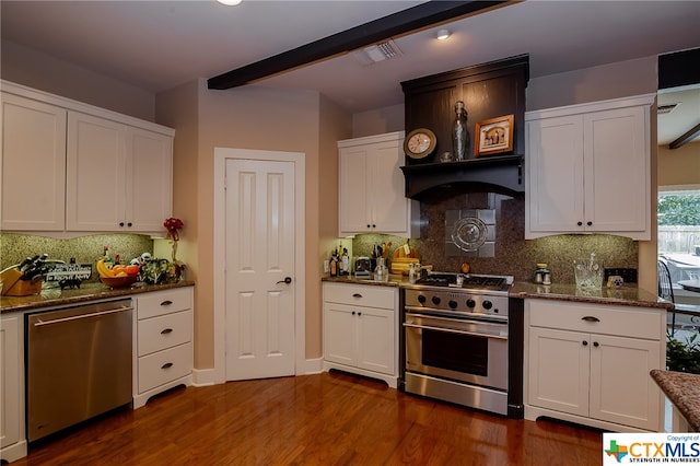 kitchen featuring stainless steel appliances, dark hardwood / wood-style flooring, dark stone counters, decorative backsplash, and white cabinetry