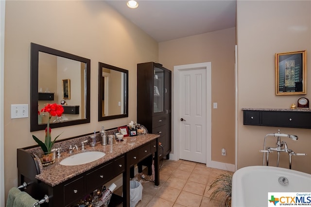 bathroom featuring a washtub, vanity, and tile patterned flooring