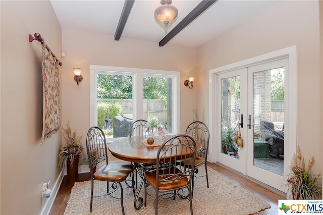 dining room featuring hardwood / wood-style floors, french doors, a healthy amount of sunlight, and beam ceiling