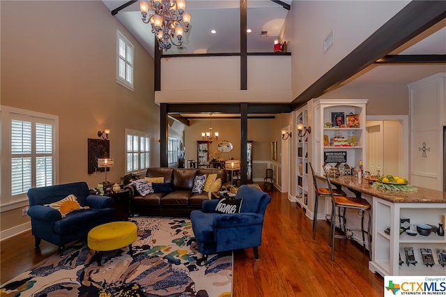 living room featuring a high ceiling, an inviting chandelier, and hardwood / wood-style floors