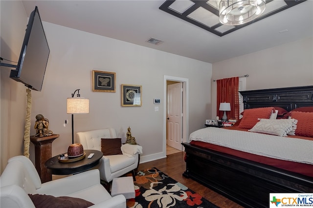 bedroom with a chandelier and dark hardwood / wood-style floors