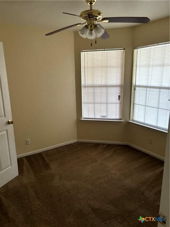 carpeted spare room featuring a wealth of natural light and ceiling fan