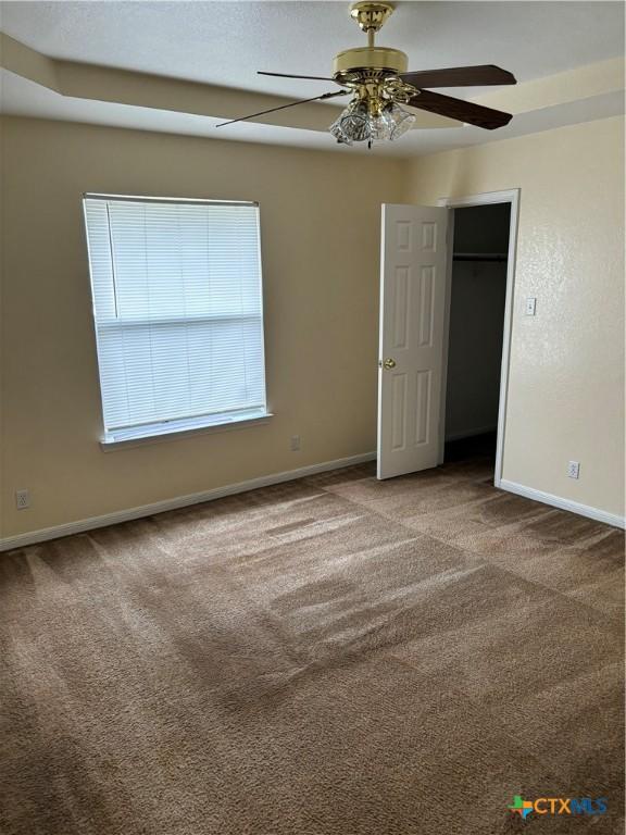 unfurnished bedroom featuring ceiling fan and carpet flooring