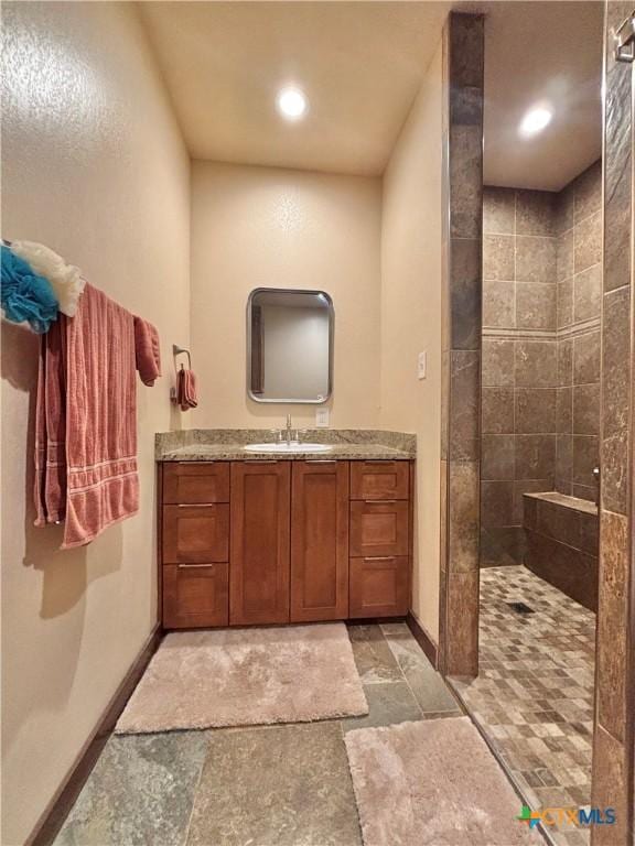 174 Riley Ln, Port Oconnor, TX 77982 - full bath with stone tile floors, vanity, a tile shower, baseboards, and recessed lighting