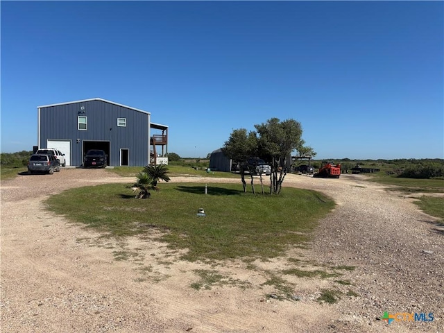 174 Riley Ln, Port Oconnor, TX 77982 - view of yard featuring driveway and a detached garage