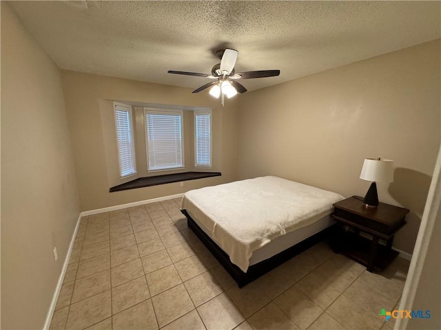 tiled bedroom with a textured ceiling and ceiling fan