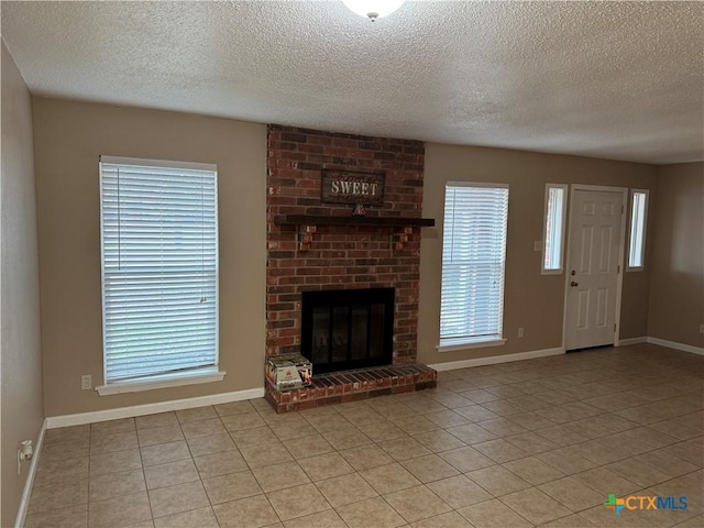 unfurnished living room featuring light tile patterned floors, a brick fireplace, and a textured ceiling