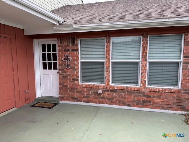 view of exterior entry featuring a patio area