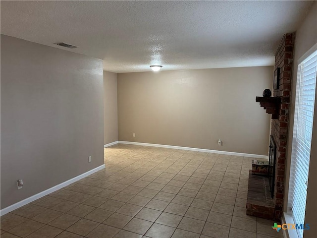 basement featuring a textured ceiling, light tile patterned floors, and a fireplace