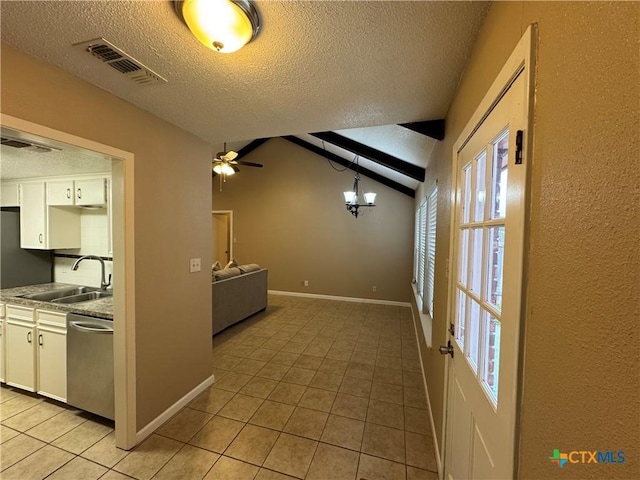 kitchen featuring stainless steel dishwasher, hanging light fixtures, white cabinets, and lofted ceiling