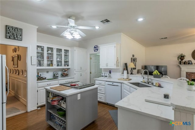 kitchen with sink, a center island, white dishwasher, white cabinets, and kitchen peninsula