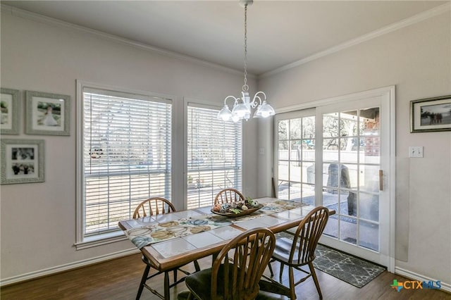 dining room featuring crown molding, dark hardwood / wood-style flooring, and a chandelier