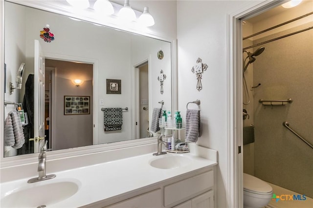 bathroom featuring vanity, toilet, and a shower