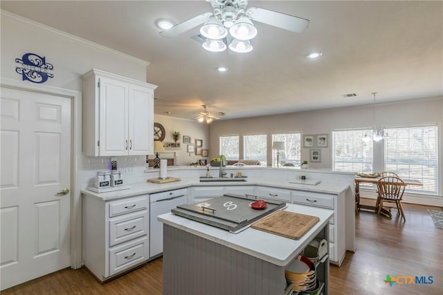 kitchen featuring sink, white cabinetry, a center island, white dishwasher, and kitchen peninsula