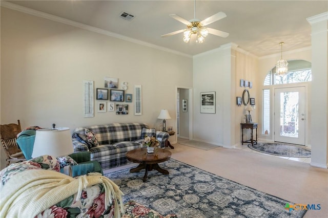 living room with crown molding, ceiling fan, carpet floors, and a high ceiling