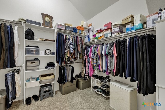 spacious closet with light colored carpet and vaulted ceiling