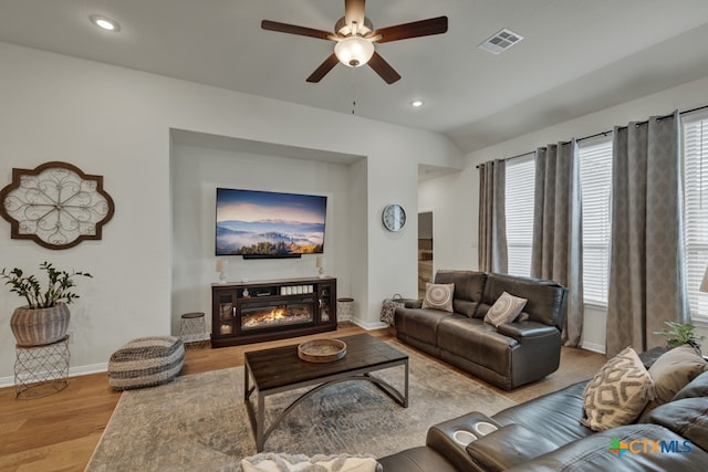 living room featuring vaulted ceiling, ceiling fan, and light hardwood / wood-style flooring