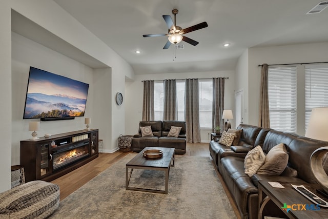 living room featuring ceiling fan and light hardwood / wood-style flooring