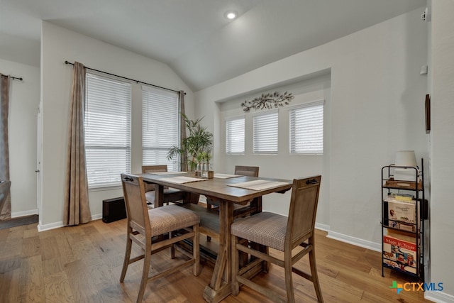 dining area featuring vaulted ceiling, light hardwood / wood-style floors, and plenty of natural light