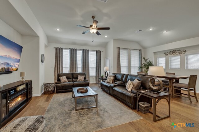 living room with light wood-type flooring, ceiling fan, and vaulted ceiling