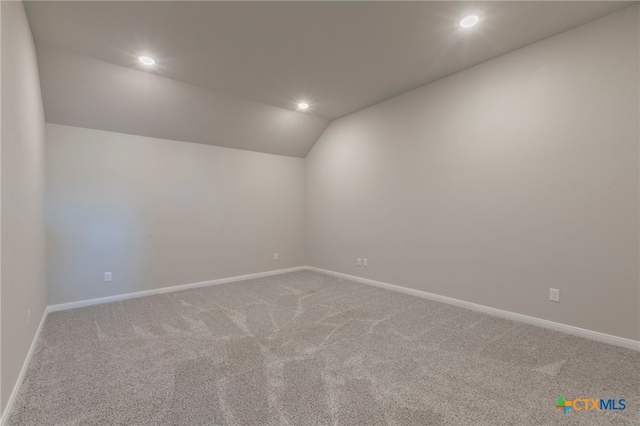 empty room featuring carpet floors and lofted ceiling