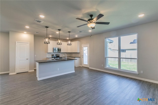 kitchen featuring stainless steel appliances, dark hardwood / wood-style flooring, white cabinets, and a healthy amount of sunlight