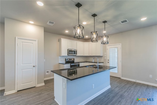 kitchen with appliances with stainless steel finishes, dark wood-type flooring, sink, decorative light fixtures, and white cabinets