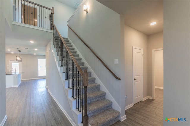 stairs with sink and hardwood / wood-style flooring