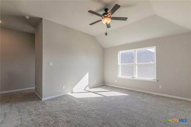 spare room featuring ceiling fan, light colored carpet, and vaulted ceiling