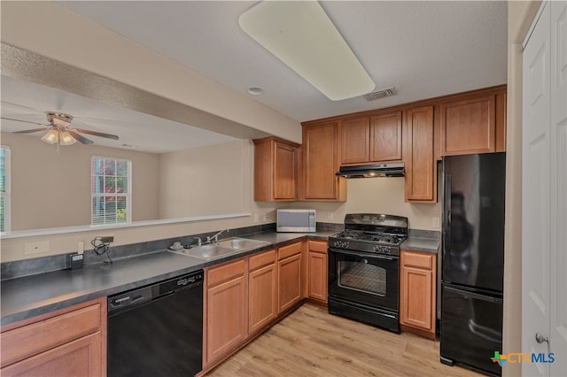 kitchen with black appliances, sink, kitchen peninsula, ceiling fan, and light hardwood / wood-style flooring