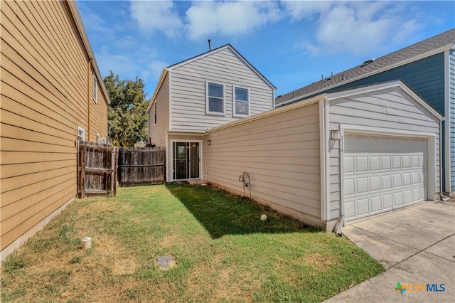 back of property with a garage and a yard