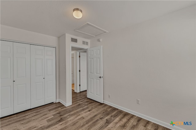 unfurnished bedroom featuring light hardwood / wood-style flooring and a closet