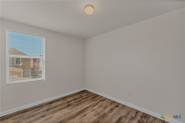 spare room featuring a wealth of natural light and hardwood / wood-style flooring