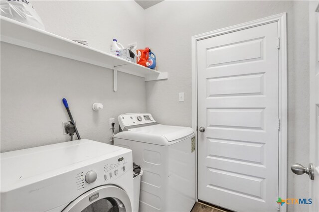 laundry room featuring hardwood / wood-style flooring and washer and clothes dryer