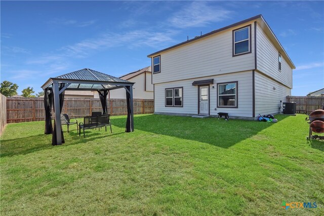 rear view of house featuring central AC unit, a yard, and a gazebo