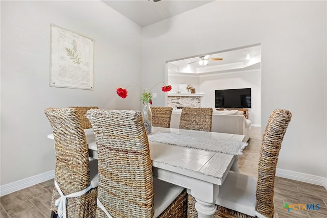 dining space featuring ceiling fan and a raised ceiling