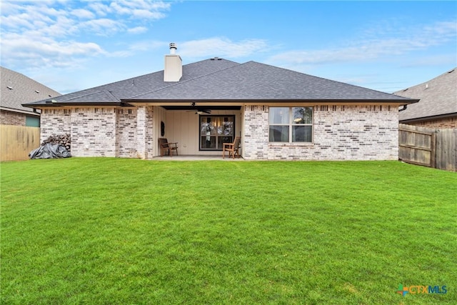 back of property featuring a patio and a lawn