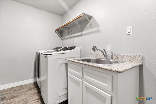 clothes washing area with cabinets, sink, and washing machine and clothes dryer