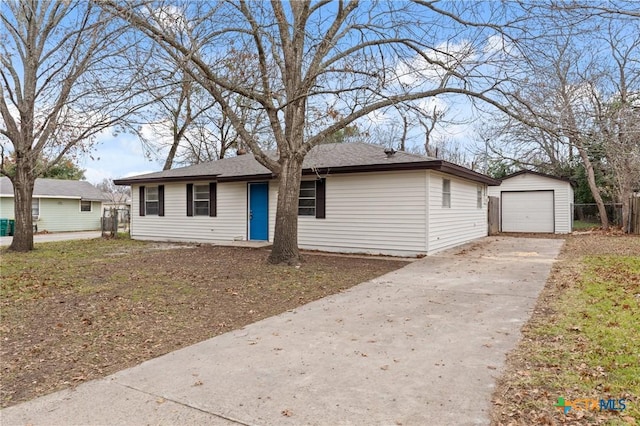 view of front facade featuring concrete driveway, an outdoor structure, and a detached garage