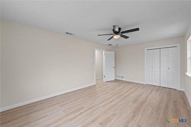 unfurnished bedroom featuring a closet, light wood-type flooring, visible vents, and baseboards