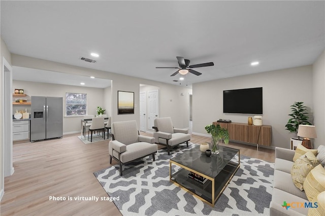 living room featuring recessed lighting, visible vents, ceiling fan, light wood-type flooring, and baseboards