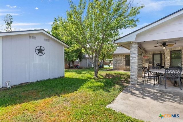 view of yard featuring ceiling fan, a patio, and a storage shed