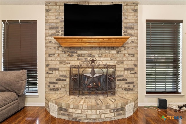 living room with dark hardwood / wood-style flooring and a brick fireplace