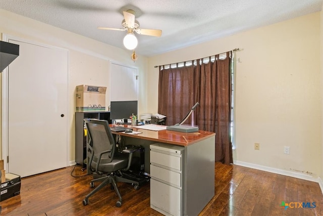 home office with a textured ceiling, dark hardwood / wood-style flooring, and ceiling fan