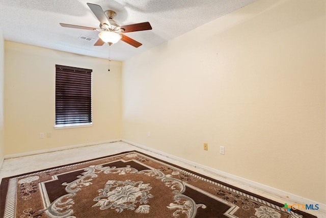 empty room featuring ceiling fan and a textured ceiling