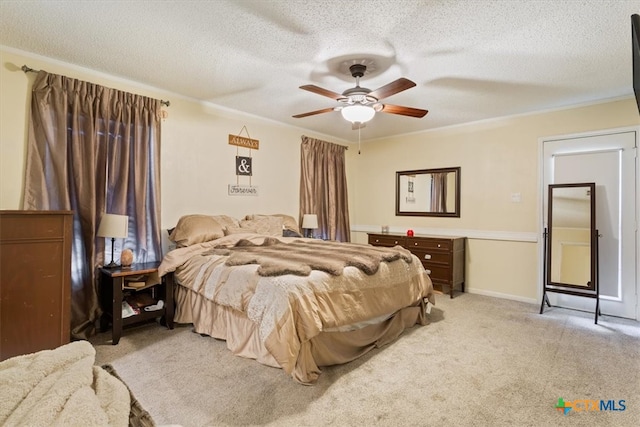 carpeted bedroom featuring ceiling fan and a textured ceiling