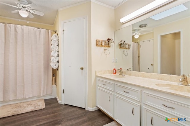 bathroom featuring a skylight, shower / bathtub combination with curtain, hardwood / wood-style flooring, vanity, and ornamental molding