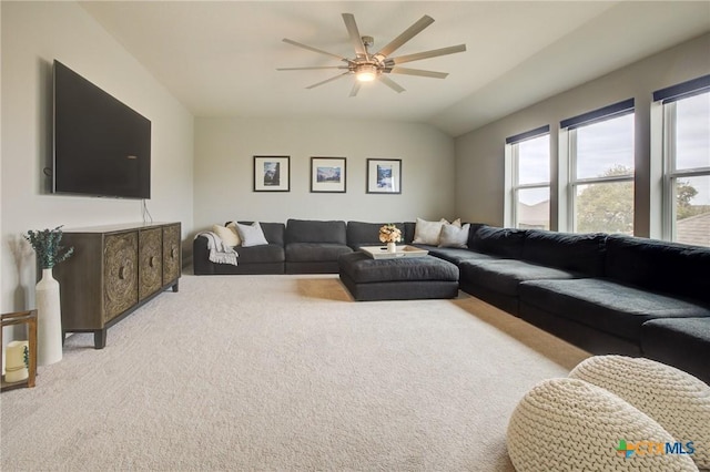 carpeted living room with ceiling fan and lofted ceiling