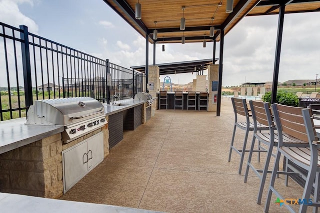 view of patio / terrace with a grill, an outdoor bar, and area for grilling